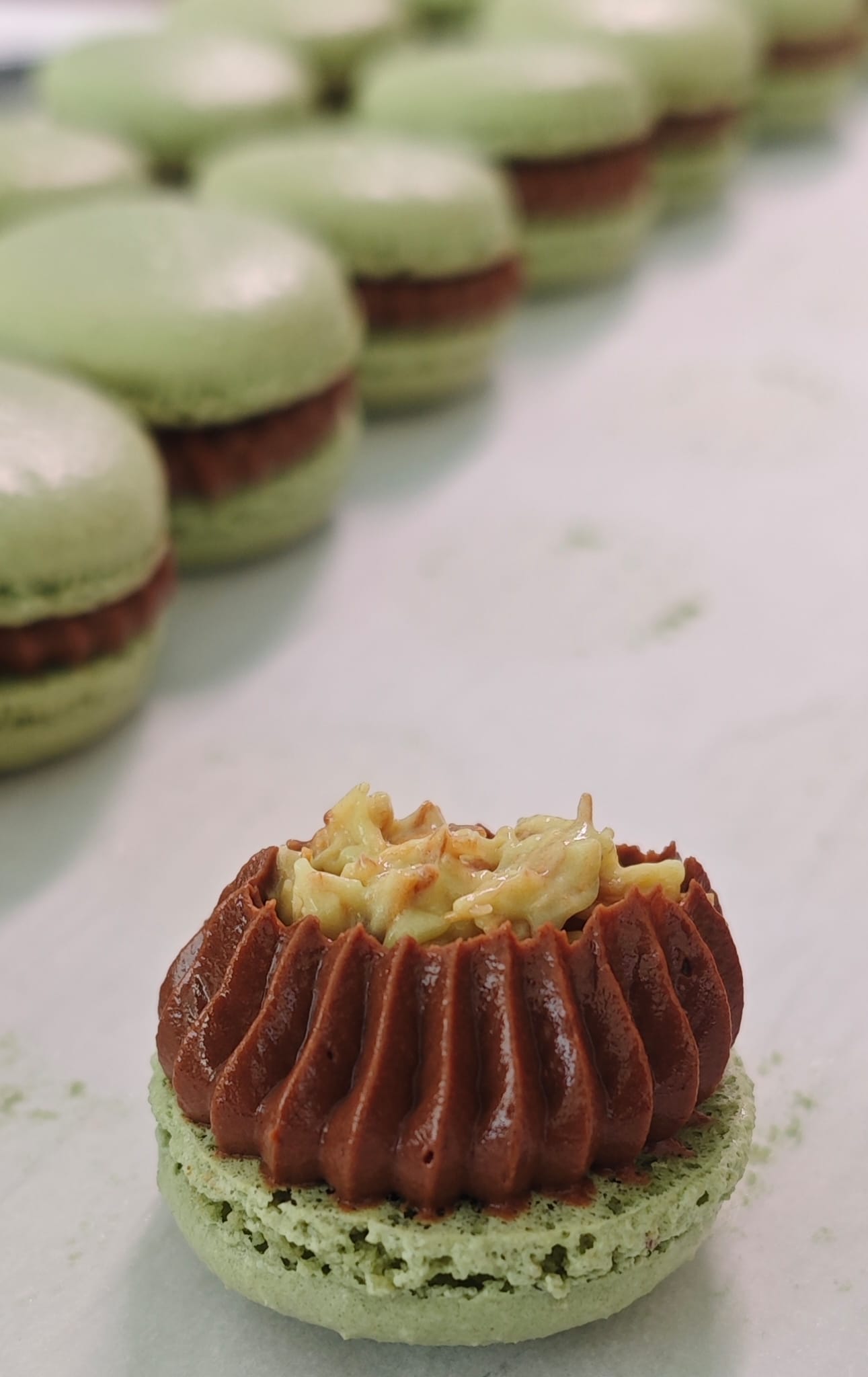 Een open macaron laat de zorgvuldig opgespoten vulling en de kern zien